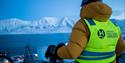 A guest on a bike looking out across mountains and a fjord from Longyearbyen