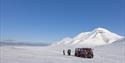 People standing next to a snowcat