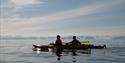 Two persons in kayaks on a fjord