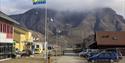 A flag with the pride colours on a flag pole in Longyearbyen's town centre