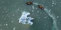 Two RIB boats sailing around an iceberg