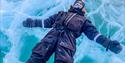 A person laying down and relaxing on ice