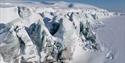 Snow-covered cliffs of ice nestle down towards the sea ice.