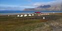 A camping site with tents and a building surrounded by fences