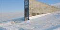 The entrance of the Seed Vault surrounded by snow on a clear and sunny winter day