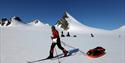 A person pulling a sled while skiing