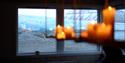 Chandelier with candles and the view of Nordenskiöld Glacier through the windows at Nordenskiöld Lodge.