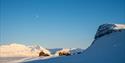 Snow-covered Arctic landscape under a blue sky.