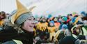 A person in a crowd with a hat resembling the sun