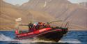 A RIB boat with guests and a guide sailing on a fjord