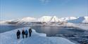 several people hiking on top of the snowcovered mountain