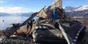 Equipment and rifle next to a cairn