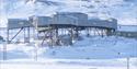 The building known as the cableway central in Longyearbyen in bright snowy surroundings