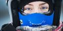 A close-up of a guest wearing snowmobile equipment and warm clothes, with frost in their eyelashes