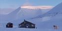 Hytten Reinheim i et snødekt landskap.