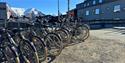 En ansatt som hjelper en gjest med en utleiesykkel