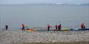 Persons preparing a kayaktrip on the beach