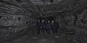 A group of guests with head lamps and helmets on, walking through a mine passage on a guided tour