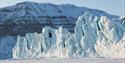 
A glacier is located in the middle of the picture with a mountain in the background.