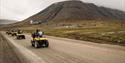 ATV tour group driving on the road in a summer landscape