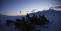 Snowmobile tour group out in the field at dusk