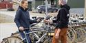 An employee helping a guest with a rental bike