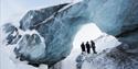 Guests talking with a guide below an ice formation