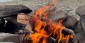 Bonfire burdning in the arctic with fjord and mountains in the background