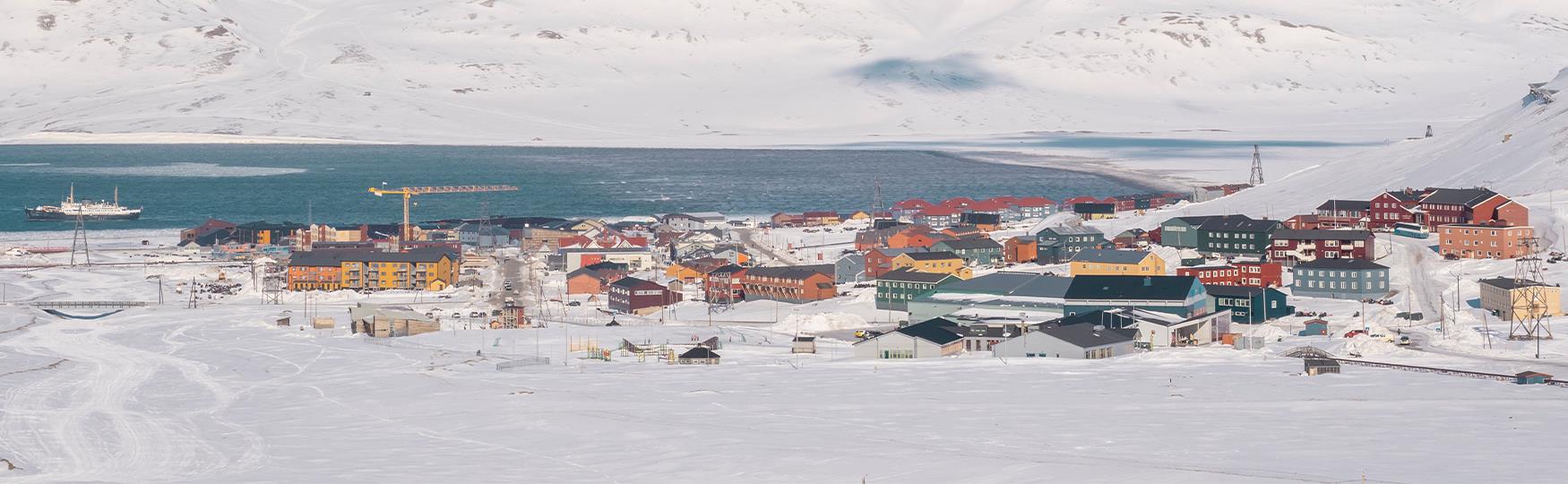 Bygninger i Longyearbyen omringet av et snødekt landskap