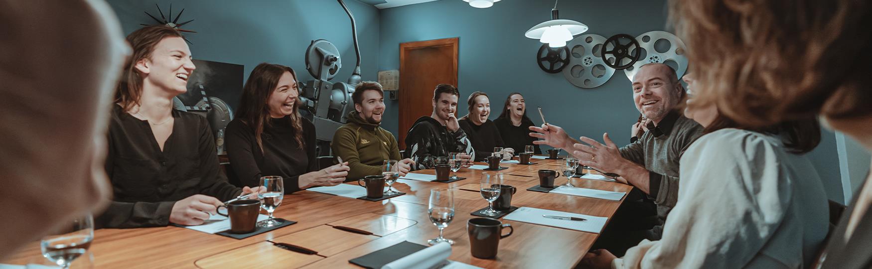 En gruppe personer som sitter rundt et bord i et møterom