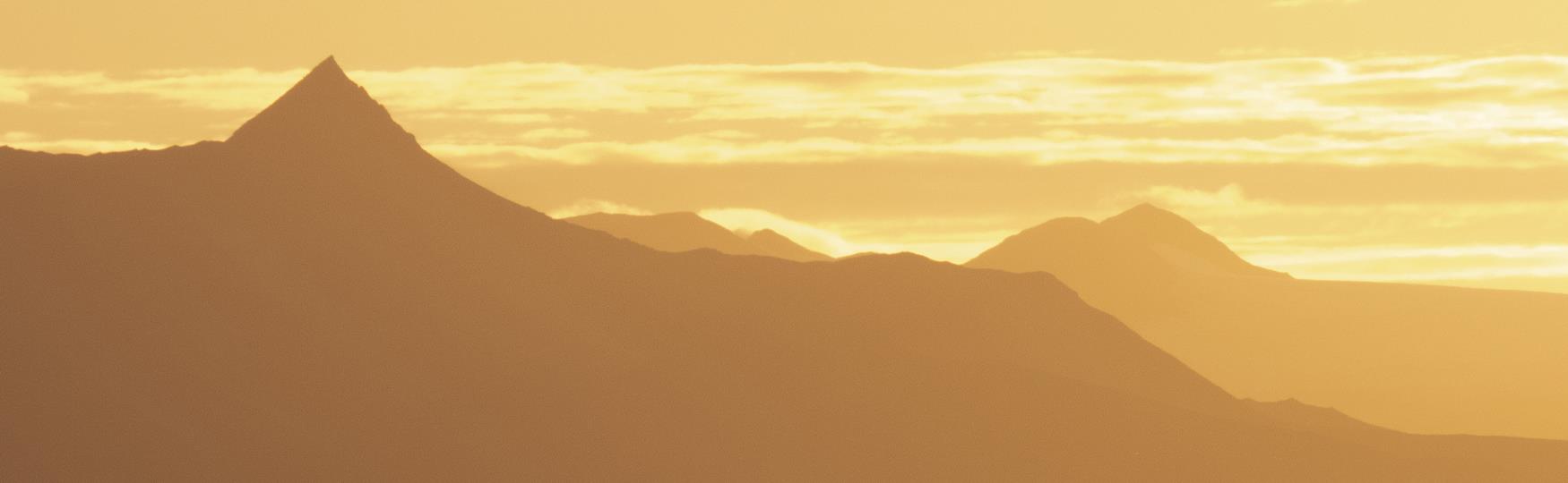 Silhouettes of mountain peaks in the midnight sun