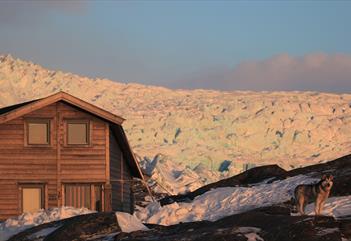 Nordenskiöld Lodge i kveldslyset med Nordenskiöldbreen i bakgrunnen