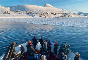 Guests on board a boat in front of the sea ice next to Barentsburg