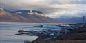 Båter langs sjøkanten og havna i Longyearbyen på en overskyet dag