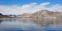 Mountainous landscapes surrounding a calm fjord