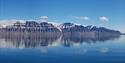 Panorama av fjellandskap langs en fjord