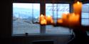 Chandelier with candles and the view of Nordenskiöld Glacier through the windows at Nordenskiöld Lodge.