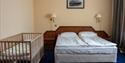 Et hotellrom på Barentsburg Hotel med en barneseng og en dobbeltseng