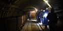 A group of guests following their guide through a tunnel in the mine