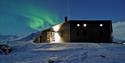Krekling Lodge with Northern Lights shining in the background