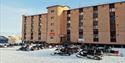 Snowmobiles parked in front of the hotel in Pyramiden