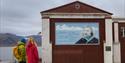 To personer som ser på et veggmaleri i Barentsburg