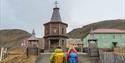 To personer som ser på kapellet i Barentsburg