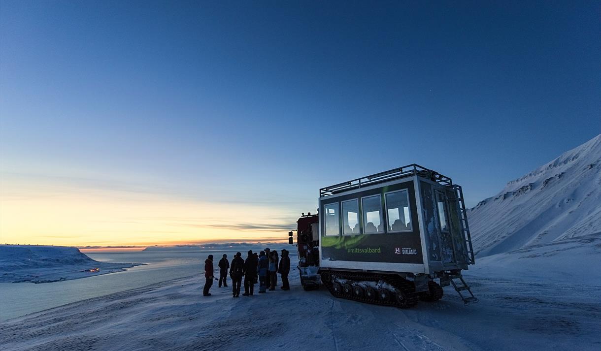People standing in front of a snowcat