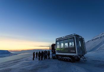 People standing in front of a snowcat