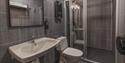 A bathroom with a sink, toilet, shower and mirror at Coal Miners' Cabins