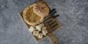 Ostefondue servert i en skål lage av brød på en trefjøl