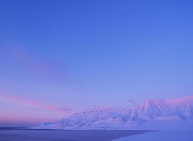 Hiorthhamn seen in the distance, in blue and pink pastel colours 
