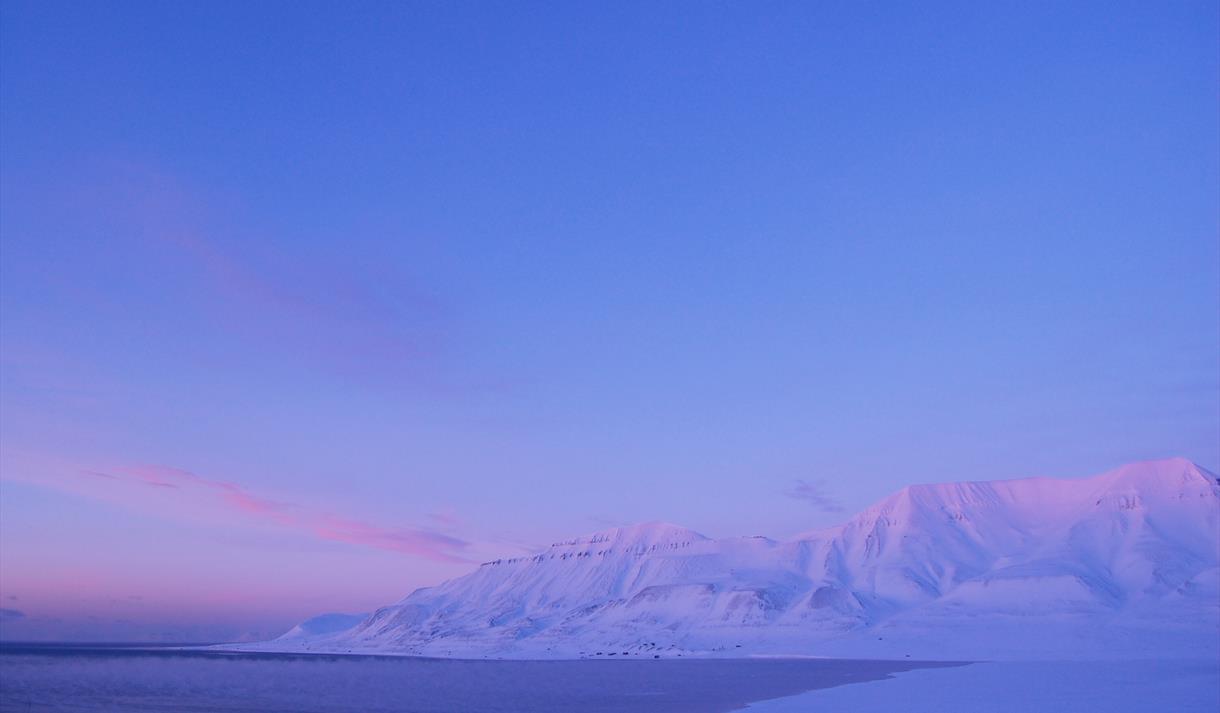 Hiorthamn seen in the distance, in blue and pink pastel colours
