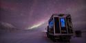 Northern Lights shining in the skies above a snowcat